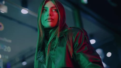 Stylish Woman Poses Under Colorful Neon Lights at Night