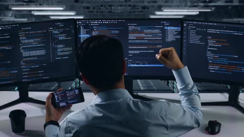 Happy Asian Man Developer Looking At Code On Mobile Phone While Write Code In Data Center