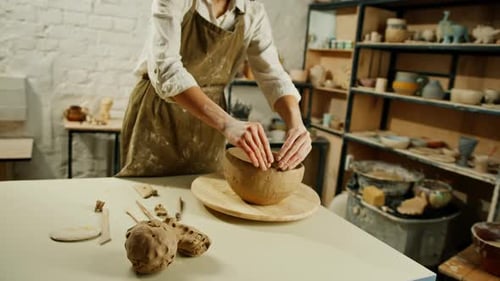 Creating handicraft pottery closeup of working table in ceramics studio with female master