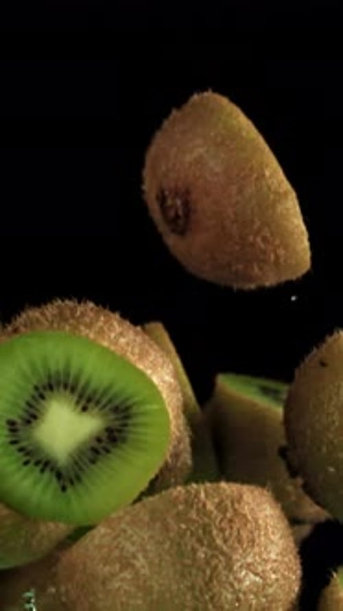 Sliced Pieces of Kiwi Fly on a Black Background Filmed on a Highspeed Camera at 1000 Fps