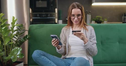 Woman on Couch Shops Online with Credit Card