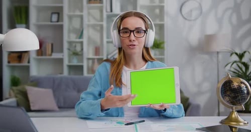 Retrato de una chica exitosa y segura de sí misma que sostiene una tableta con pantalla verde