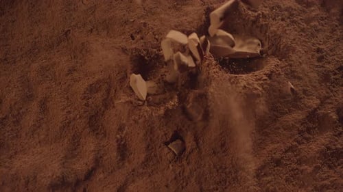 Raw Chocolate Chunks Falling Into Powdered Chocolate in Super Slow Motion Top View of Pieces of