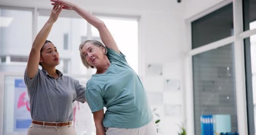 Senior Woman Exercising with Physical Therapist in Clinic