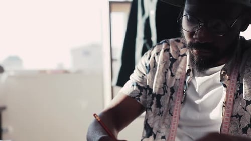 Tailor Sketching Design in Bright Studio, Close Up