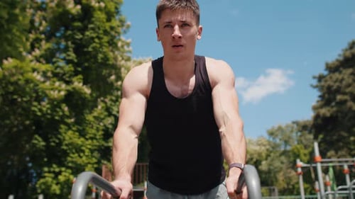 Muscular Man Doing Dips in Outdoor Gym
