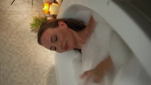 Woman Relaxes in Bubbles in a Bathtub