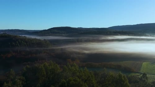 Foggy Clouds Engulfing Forest And Lake Near Paiosaco, A Laracha, A Coruna, Spain. Aerial Drone Shot
