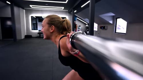 Strong Woman Lifts Weights in Modern Gym During Early Morning Workout Session