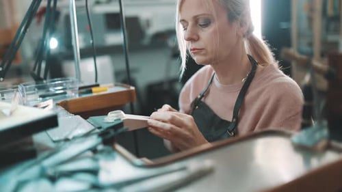 Woman Jeweler Crafting a Metal Ring in Her Workshop
