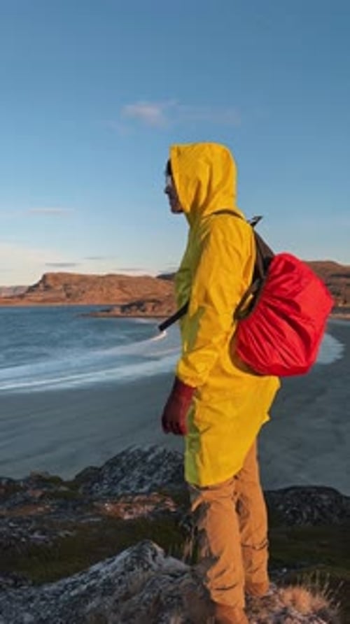 Traveler in Bright Clothes Surrounded By Breathtaking View of the Sea Completes a Hike to Ocean