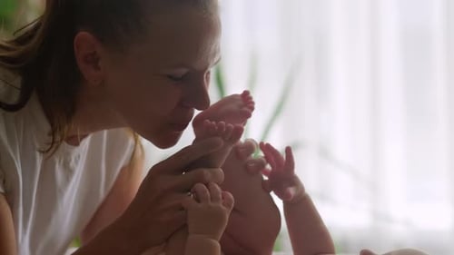 Loving Mother Playing with Baby's Feet