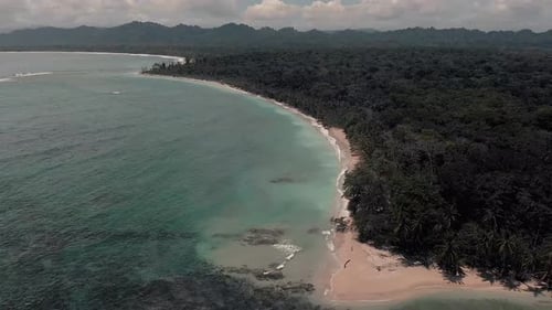 Flying Around The Costa Rica Beach With Vast Green Forest On The Ground. -aerial shot