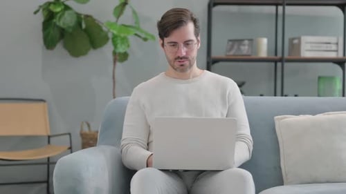 Man With Headache Working on Laptop at Home