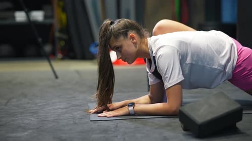 Sporty Woman in Activewear Doing Stretching Exercise in Gym