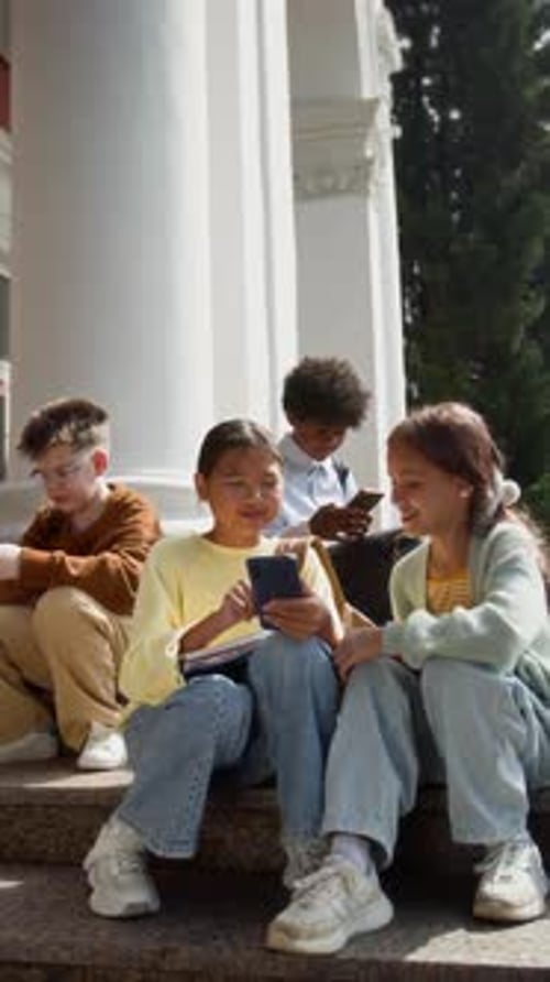 Friendly Diverse Group of Four Teens Relaxing on Steps After school