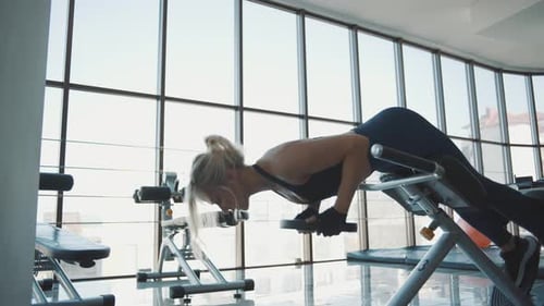 Strength training workout by a female trainer at a modern gym in the afternoon