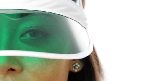 4k video footage of a young woman wearing a sun visor against a white studio background