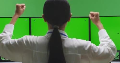 Woman Celebrating And Dancing While Working With Mock Up Multiple Computer Monitor In Green Screen