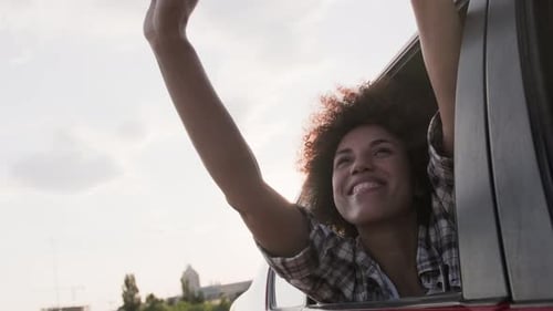 Smiling Young Woman Enjoying the View From Car During Trip Slow Motion