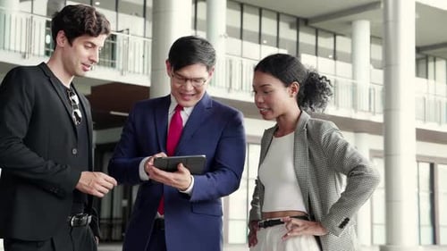 Group young business man and woman meeting and discussing documents on a tablet in modern office.
