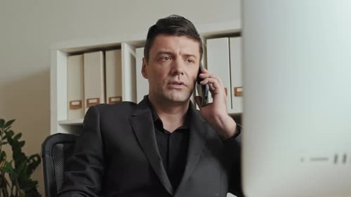 Man in Suit Talking on Cell Phone in Office