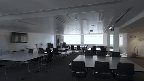 A panoramic view of the empty boardroom or conference room, adorned with chairs and tables, pan left