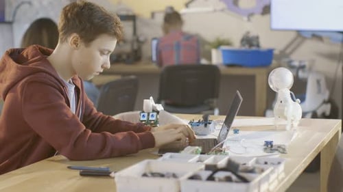 Smart Young Boy Works on a Laptop For His New Robot Programing Project in Computer Science Class. O