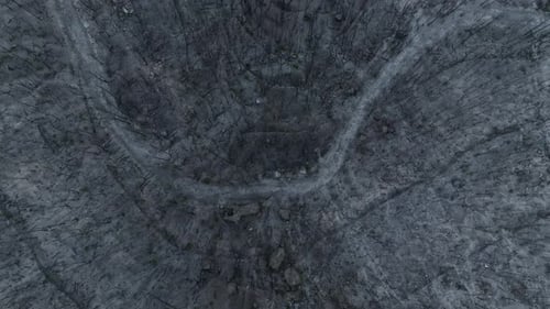 Top down aerial drone of dead grey dark forest after violent bush fire, zoom out