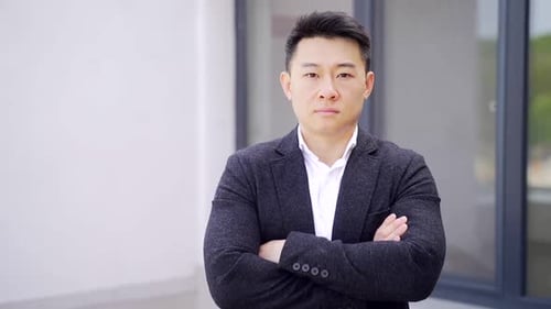 Portrait of young serious asian businessman with arms crossed and confident. looking at the camera.