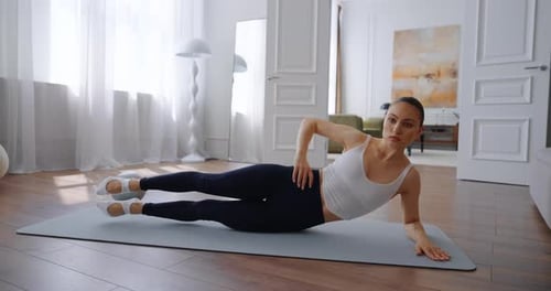 Woman Doing Leg Lifts on Yoga Mat at Home