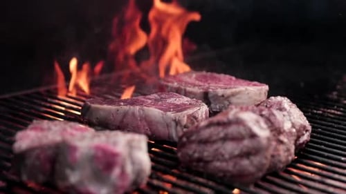 Raw steak on a wood fire grill