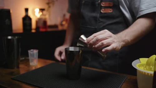 Bartender expertly mixes cocktail with egg white in cozy home bar setting. Perfect for hobbyists and