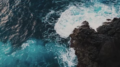 Top Down View Of Intense Blue Ocean Waves Crashing Rocks