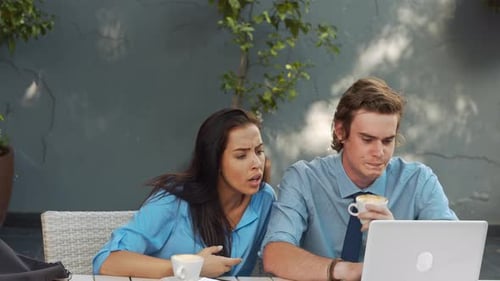 Woman and man working at cafe with laptop