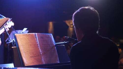 Pianist Performing on Stage at Night