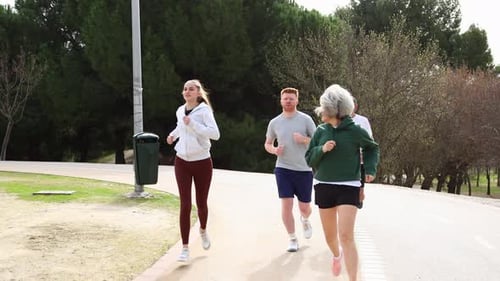 Group of People of Different Ages Running Together in a Park
