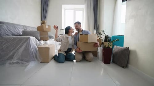 Happy Couple Celebrating Moving Into New Home with Keys