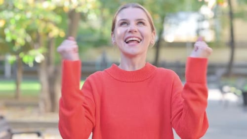 Woman Smiling and Celebrating Outdoors in a Park
