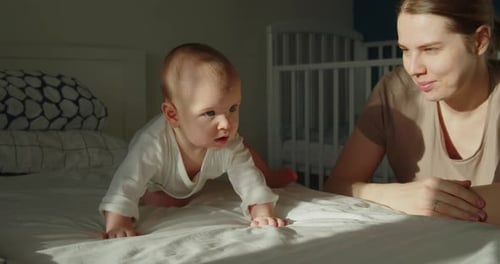 Little Baby Boy Trying to Stand on All Fours and Crawl on a Bed