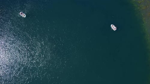 vista aérea se afastando, foto de uma lagoa com e pessoas em barcos