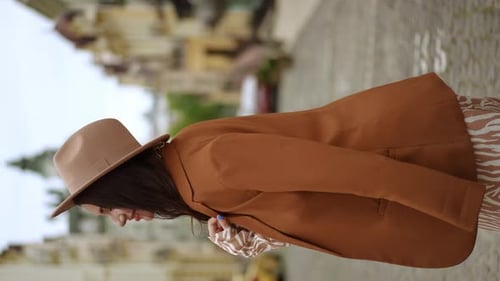 Stylish Woman Walks Along Cobblestone Street