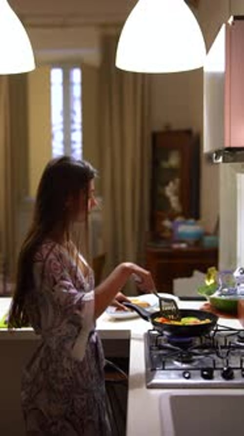 Woman Cooking Colorful Vegetables on Stove in Kitchen