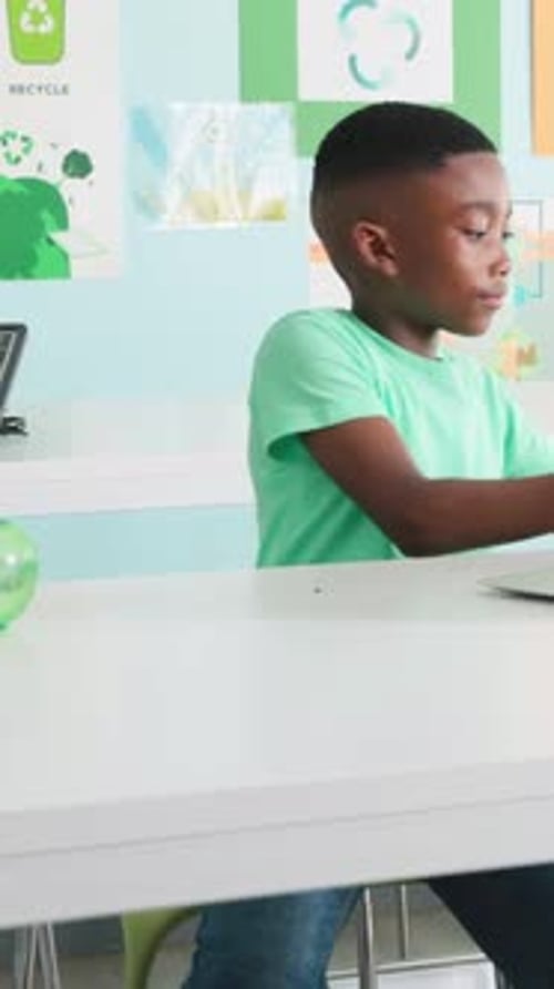 Vertikales Video: Schüler im grünen Tee erreichen, Samenschale mit Laptop heben und Farn für den Unterricht lernen