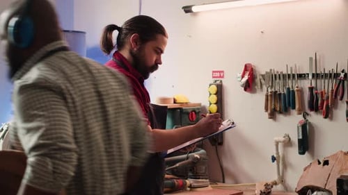 Carpenter Drawing Blueprints on Notepad in Studio
