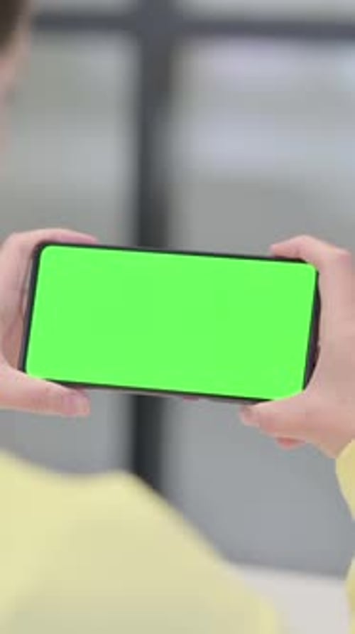 Woman Looking at Smartphone with Green Screen, Vertical Video