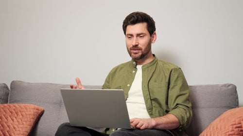 Man On Couch Talking to Laptop