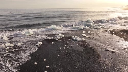 aerial - ice fragments scattered on black coast diamond beach iceland