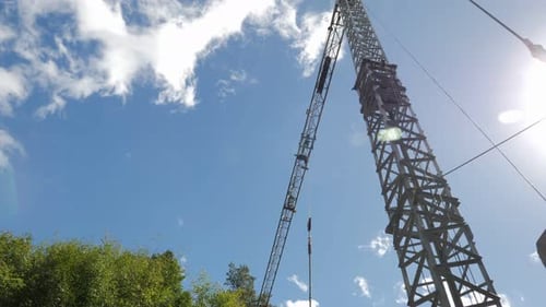 High construction crane carrying building materials on construction site