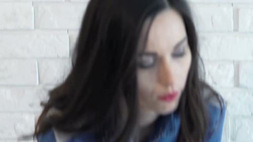 Sad Woman Drinks Wine Near White Brick Wall